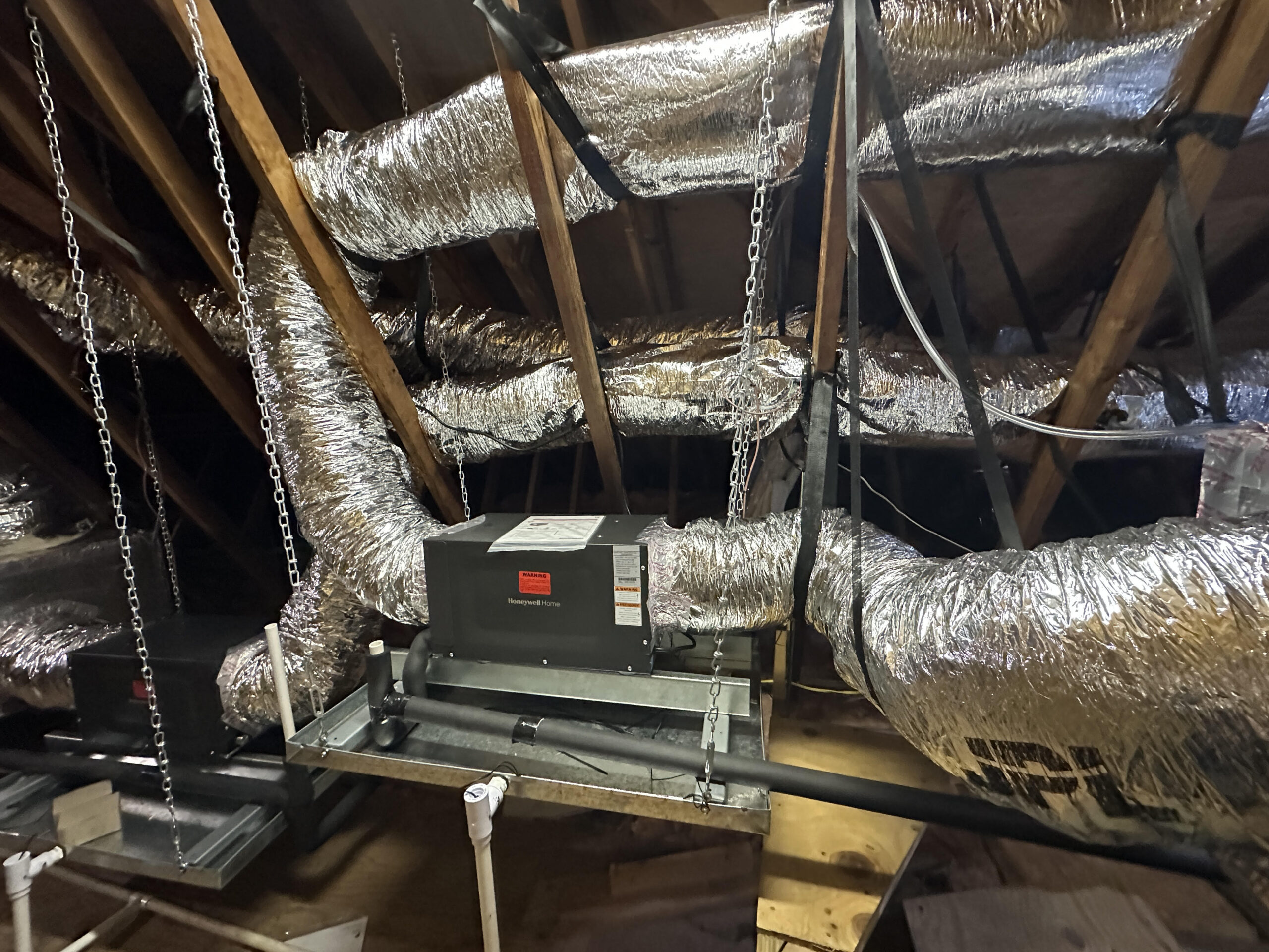 Inline HEPA filtration system installed in an attic, integrated with insulated ductwork for enhanced indoor air quality.