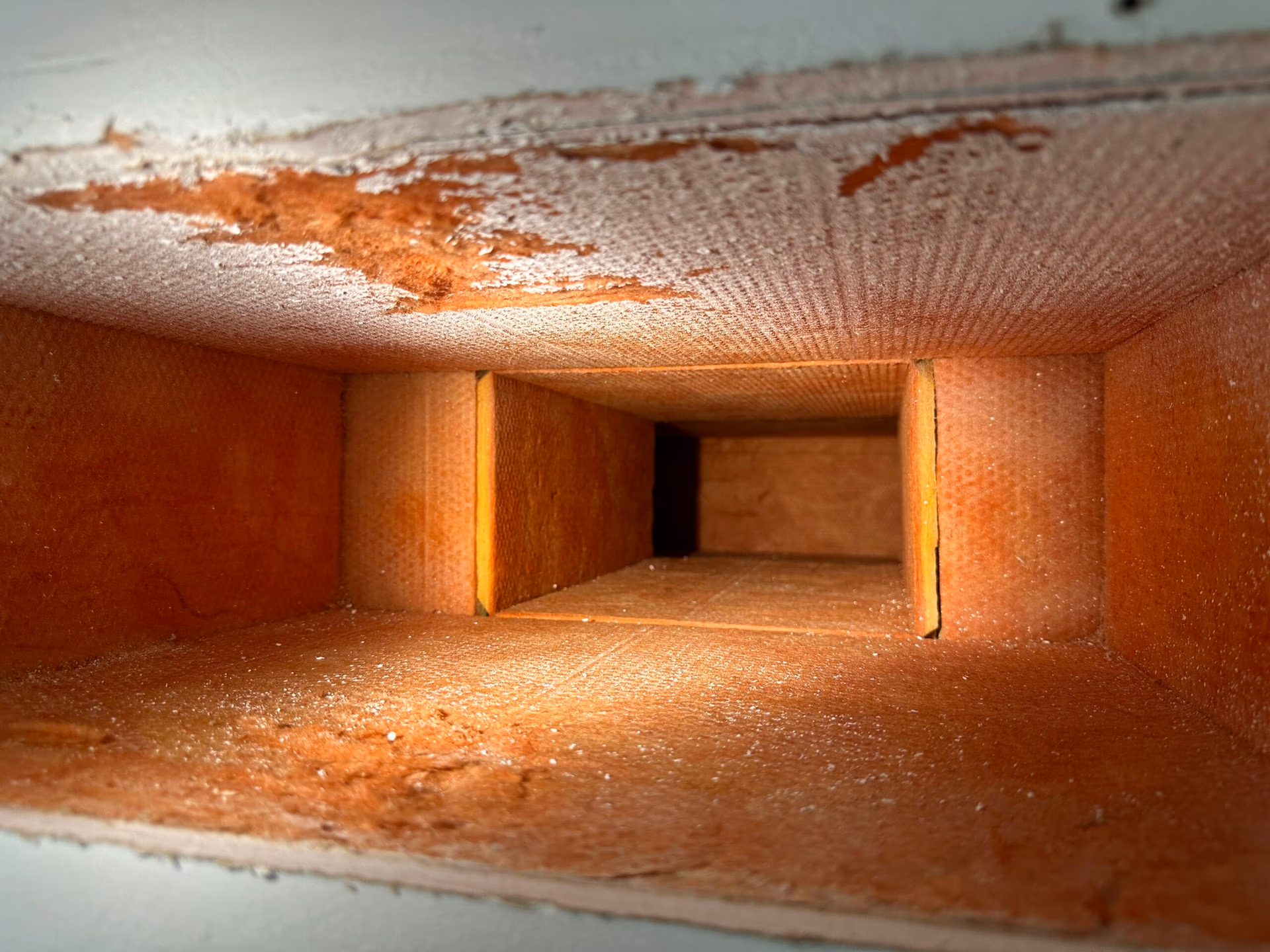 Interior of HVAC ductwork showing dust buildup and impacted duct surfaces prior to professional duct cleaning and remediation.