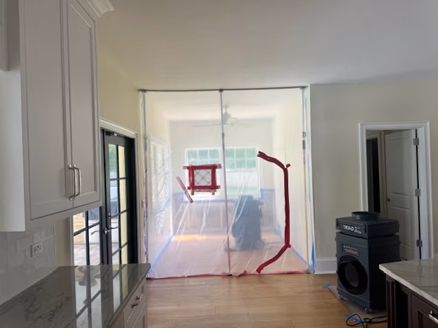 A plastic containment barrier set up in a living area during mold remediation to prevent the spread of spores.