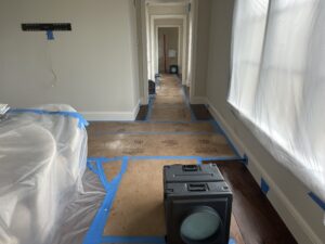 Hallway prepared for mold remediation with containment barriers and drying equipment.