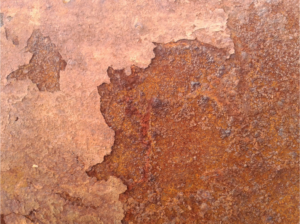 Close-up of rust on the panel of an A/C unit.