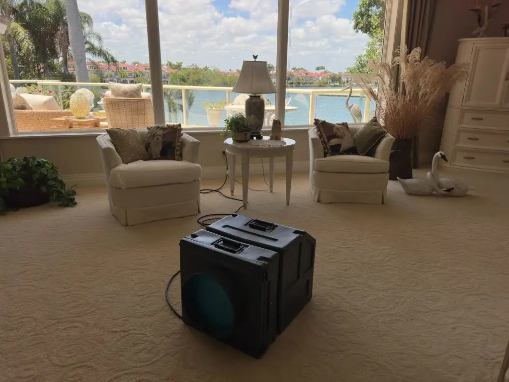 Air scrubber running in a residential living room to remove mold spores and purify indoor air after remediation.