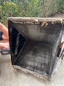 HVAC evaporator coil removed from system showing heavy debris and buildup along the fins
