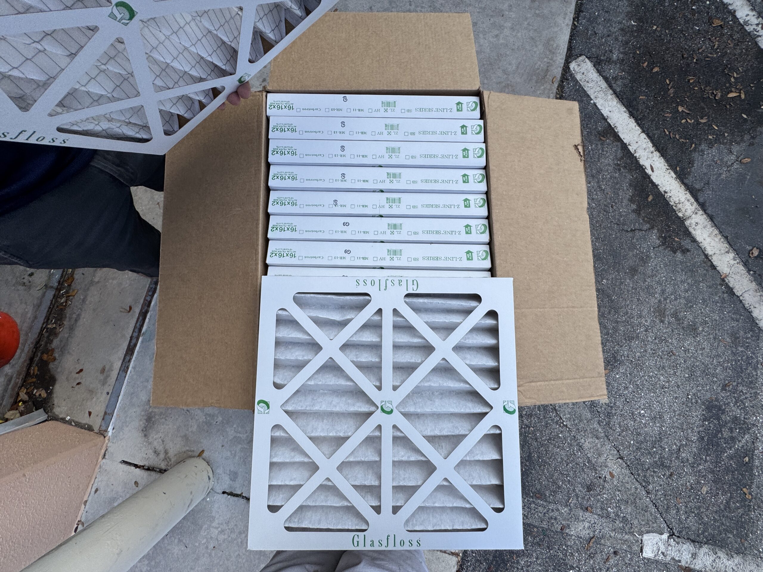 Box of Glasfloss Z-Line Series 16x16x2 MERV 11 pleated air filters, with one filter removed and displayed in front of the open box.