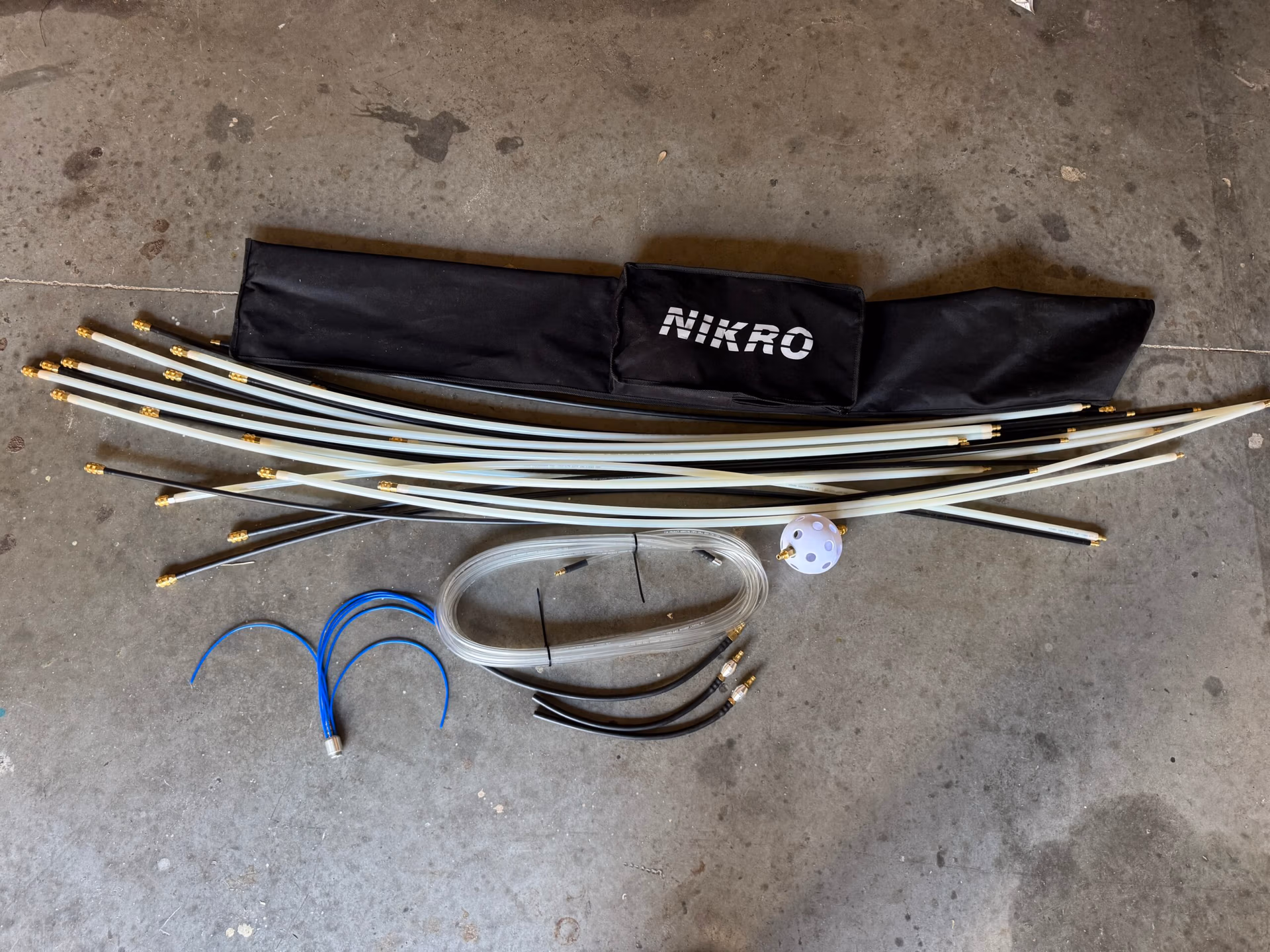 Nikro air duct whip blast system with flexible whip rods, air hoses, and agitation head used for professional HVAC duct cleaning and debris removal.